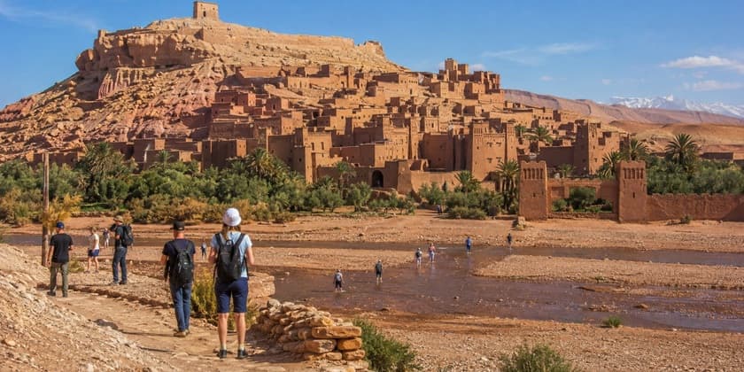 Travelers exploring earthen buildings at Ait Ben Haddou